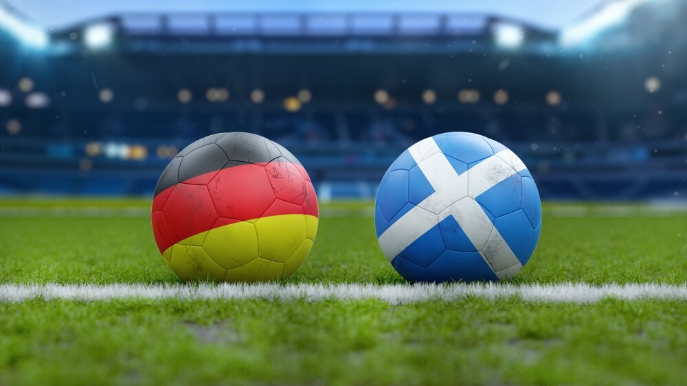 Soccer,Balls,With,Germany,And,Scotland,Flags,On,Grass,Field